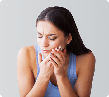 A woman holding her jaw in pain.