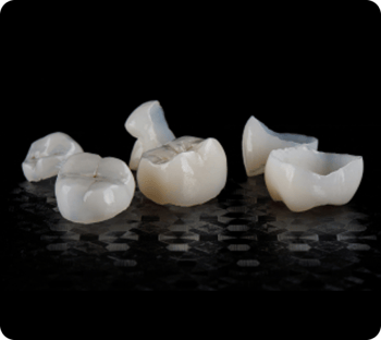 Close up of dental crowns on a black background.