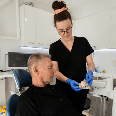 Mulgrave Dental Group dentist showing a dental model to a patient.