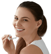 Smiling woman holding a clear aligner.