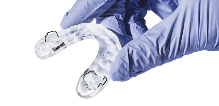 Gloved hand holding a dental splint.