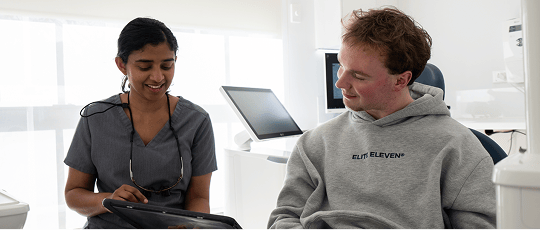 Dr. Diluni and a Mulgrave Dental Group patient in a consultation, looking at a tablet together.