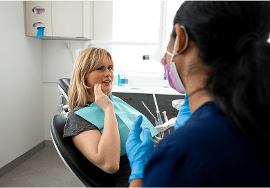 A Mulgrave Dental Group patient pointing at pain in their jaw while in a consultation with a dentist.