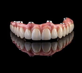 Close up of a dental implant on a black background.