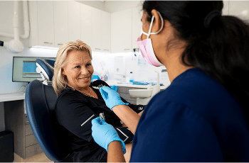 Dr. Diluni holding some Invisalign clear aligners while in a consultation with a Mulgrave Dental Group patient.