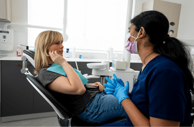 Mulgrave Dental Group patient pointing out pain in their jaw while in a consultation with Dr. Diluni.
