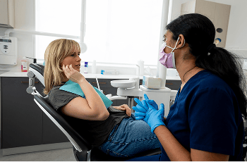 Mulgrave Dental Group patient pointing out pain in their jaw while in a consultation with Dr. Diluni.