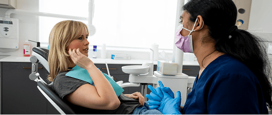 A Mulgrave Dental Group patient pointing at pain in their jaw while in a consultation with a dentist.