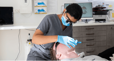 Dr. Diluni examining a patient’s mouth during a consultation at Mulgrave Dental Group.