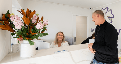 Smiling Mulgrave Dental Group patient interacting with the friendly front-desk staff.