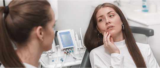 Patient describing her dental pain to a dentist during a consultation.