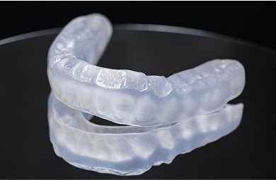 Close up of a dental splint on a black background.