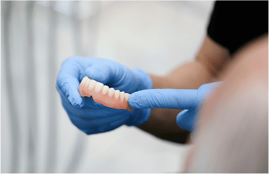 Close up of a dentist holding dentures.