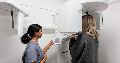 Mulgrave Dental Group Principal Dentist Dr. Diluni with a patient at the CBCT X-ray machine.