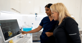 Mulgrave Dental Group patient and Dr. Diluni looking at the computer together, in a dental consultation.