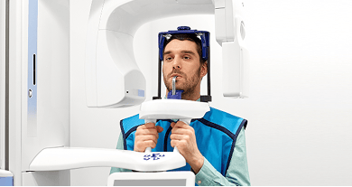 Man undergoing a CBCT (Cone Beam CT) scan, positioned in the imaging machine for a detailed 3D view of teeth and jaw structures.