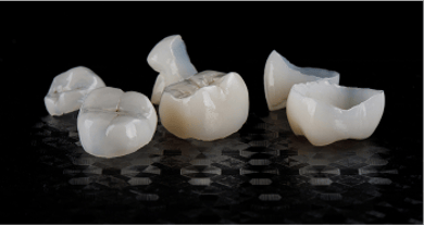 Close up of dental crowns on a black background.