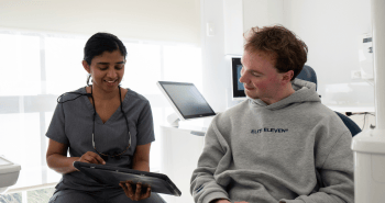 Dr. Diluni and a Mulgrave Dental Group patient in a consultation, looking at a tablet together.