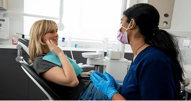 A Mulgrave Dental Group patient pointing at pain in their jaw while in a consultation with a Dr. Diluni.