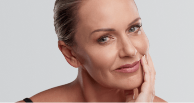 Middle-aged woman with smooth, youthful skin gently touching her face.