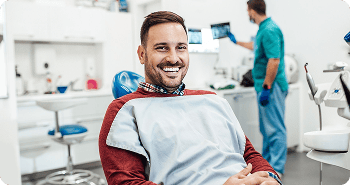 Smiling man in the dentist's chair at a dental clinic.