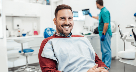 Smiling man sitting in a dentist chair.