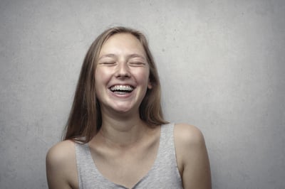 Image of a girl smiling brightly, showing teeth with braces.